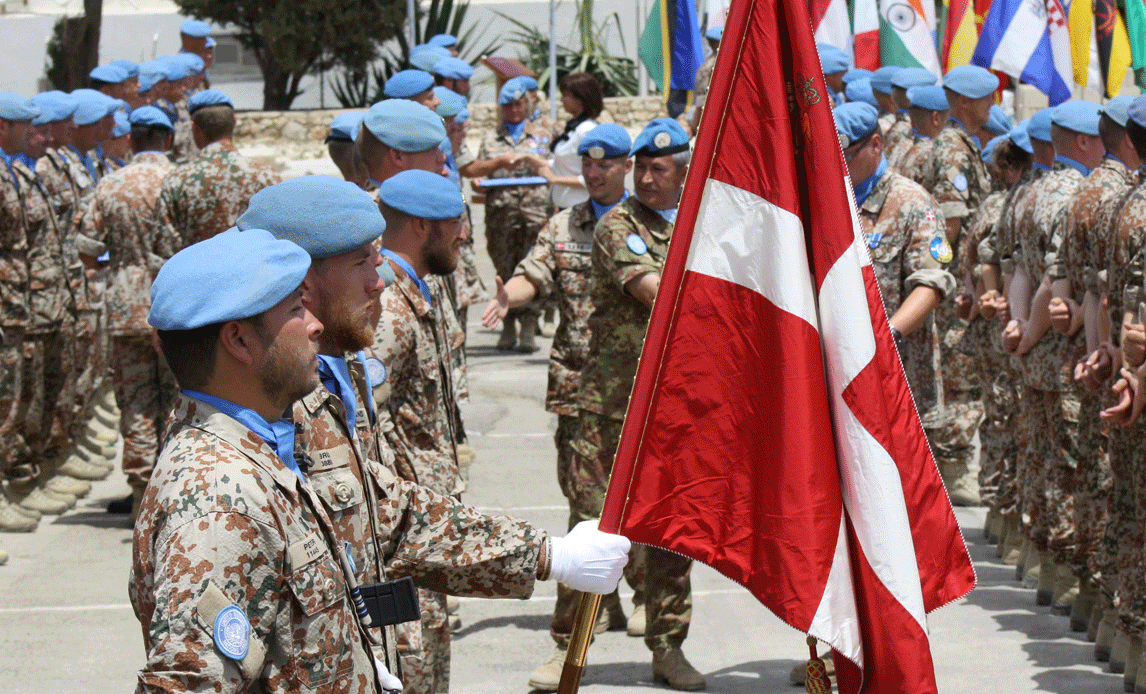 Parade for hold 2 på UNIFIL i Libanon. I paraden er soldater med blå FN-baretter. En af soldaterne holder en fane med dannebrog.